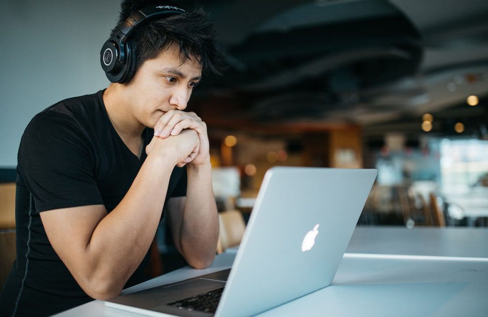 Junger Mann am Laptop in der Onlinevorbereitung